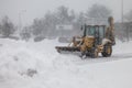 Snow plow machinery during snow storm day cleaning parking lot onshopping plazza