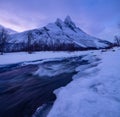 Norway. Frozen river and mountain. A classic view in Norway during winter. Cold weather and a snow storm.