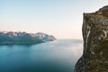 Norway landscape man standing on cliff rock edge above fjord Senja mountains travel hiking adventure