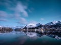 Norway, Lofoten island. Mountains and reflections on water at night. Winter landscape. The sky with stars and Aurora borealis. Royalty Free Stock Photo