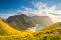 Norway. Lofoten islands. Beautiful autumn landscape. Sunny hills with soft grass by the fiord illuminated by evening sun.