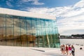 Norway, Oslo August 1, 2013: Girls walk along the waterfront. Tourists take photos and admire the panorama of Oslo from the Opera