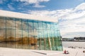 Norway, Oslo August 1, 2013: Girls walk along the waterfront. Tourists take photos and admire the panorama of Oslo from the Opera