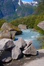 Norway. Water flow from the thawing glacier Briksdayl in mountains in the summer afternoon