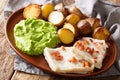 Norwegian cod lutefisk served with pea puree, potatoes and bacon close-up. horizontal Royalty Free Stock Photo