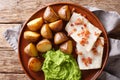 Norwegian cod lutefisk served with pea puree, potatoes and bacon close-up. Horizontal top view Royalty Free Stock Photo