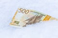 Norwegian 500 kroner lying in the snow, Financial concept, spending freeze