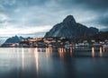 Norwegian fishing village Reine at the Lofoten Islands in Norway. Dramatic sunset clouds moving over steep mountain Royalty Free Stock Photo