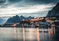 Norwegian fishing village Reine at the Lofoten Islands in Norway. Dramatic sunset clouds moving over steep mountain Royalty Free Stock Photo