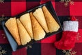 Norwegian Krumkake cookies on a black ceramic plater, holiday tablecloth, red and white Christmas stocking Royalty Free Stock Photo