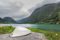 Norwegian landscape with a boat on lake against mountains. Fishing boat on a still lake in Norway and high mountains in background Royalty Free Stock Photo