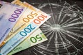 Norwegian money on broken glass, concept of weakness of Norwegian krone Royalty Free Stock Photo