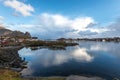 Norwegian old city Reine with reflections in water and cloudy sk