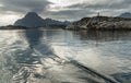 Norwegian seascape, lighthouse on the island, rocky coast with dramatic skies, the sun breaks through the clouds, sheer