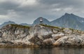 Norwegian seascape, lighthouse on the island, rocky coast with dramatic skies, the sun breaks through the clouds, sheer