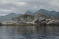 Norwegian seascape, lighthouse on the island, rocky coast with dramatic skies, the sun breaks through the clouds, sheer