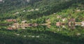 Norwegian village with red small houses in summer green forest, scenic fjord in Norway Royalty Free Stock Photo