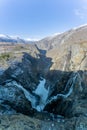 Norwegian Voringfossen waterfall in early spring, leftover ice left over from winter in the Bjoreio valley in the Eidfjord Royalty Free Stock Photo