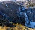 Norwegian Voringfossen waterfall in early spring, leftover ice left over from winter in the Mabodalen valley in the Eidfjord Royalty Free Stock Photo