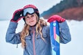 Norwegian woman wearing ski suit,holds hand goggles