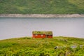 Norwegian wooden summer house overlooking scenic lake, Norway, Scandinavia. Cottage By Lake In Rural. Peat roofed hut on Lake. Royalty Free Stock Photo