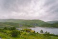 Norwegian wooden summer house overlooking scenic lake, Norway, Scandinavia. Cottage By Lake In Rural. Peat roofed hut on Lake. Royalty Free Stock Photo