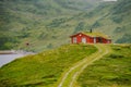 Norwegian wooden summer house overlooking scenic lake, Norway, Scandinavia. Cottage By Lake In Rural. Peat roofed hut on Lake. Royalty Free Stock Photo