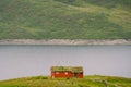 Norwegian wooden summer house overlooking scenic lake, Norway, Scandinavia. Cottage By Lake In Rural. Peat roofed hut on Lake. Royalty Free Stock Photo