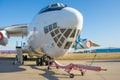 The nose and front of the cockpit of a military transport cargo aircraft, towing and taxiing carriers in front of the landing gear