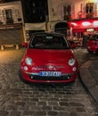 Nose of red Fiat parked on evening street in Montmartre, Paris, France