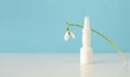 Nose spread and snowdrop flower. Allergy. One white bottle and flower. Medical concept.Copyspace. Banner, space for text