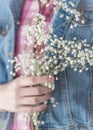 Girl`s hand holding delicate white baby`s breath flowers
