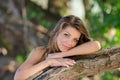 Nostalgic moments of a beautiful girl as she rests on a tree trunk Royalty Free Stock Photo