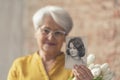 nostalgic photo of an old caucasian granny holding an old photo of her younger self