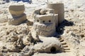 Nostalgic scene with sand castles in several stages of being built on sandy shores of