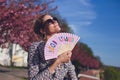 Nostalgic woman holding good times hand fan in sunset