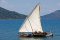 Malagasy man on sea in traditional handmade dugout wooden sailing boat