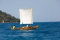 Malagasy man on sea in traditional handmade dugout wooden sailing boat