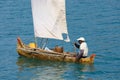 Malagasy man on sea in traditional handmade dugout wooden sailing boat