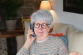 Nosy senior woman using landline phone Royalty Free Stock Photo