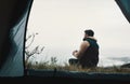 Not all classrooms have four walls. Rearview shot of a young man drinking coffee while camping in the wilderness.