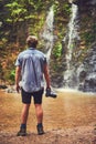 Not all who wander are lost. Rearview shot of a young photographer admiring a waterfall in the jungle.