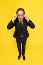 Funny excited middle aged business man showing sideways looking at camera isolated on yellow background. Handsome mature Royalty Free Stock Photo