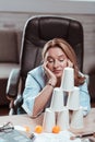 Businesswoman feeling not inspired looking at plastic pyramid