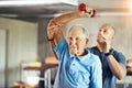 Not letting age affect his agility. Shot of a senior man working out with the help of a trainer. Royalty Free Stock Photo