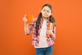 This is not my cup of tea. Dissatisfied girl looking at cup during lunch on orange background. School child having lunch Royalty Free Stock Photo