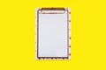 Not a standard notebook with a clip-on white paper holder on a yellow background Royalty Free Stock Photo