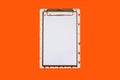 Not a standard notepad with a clip-on white paper holder on a orange background Royalty Free Stock Photo