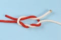 Not tightened rope Surgeon`s knot on a blue background