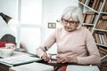 Attentive senior female person making useful notes